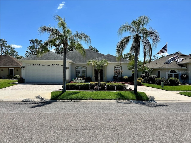 1201 Ventana Dr, Sun City Center, FL 33573 - view of front of home with a front yard, an attached garage, driveway, and stucco siding