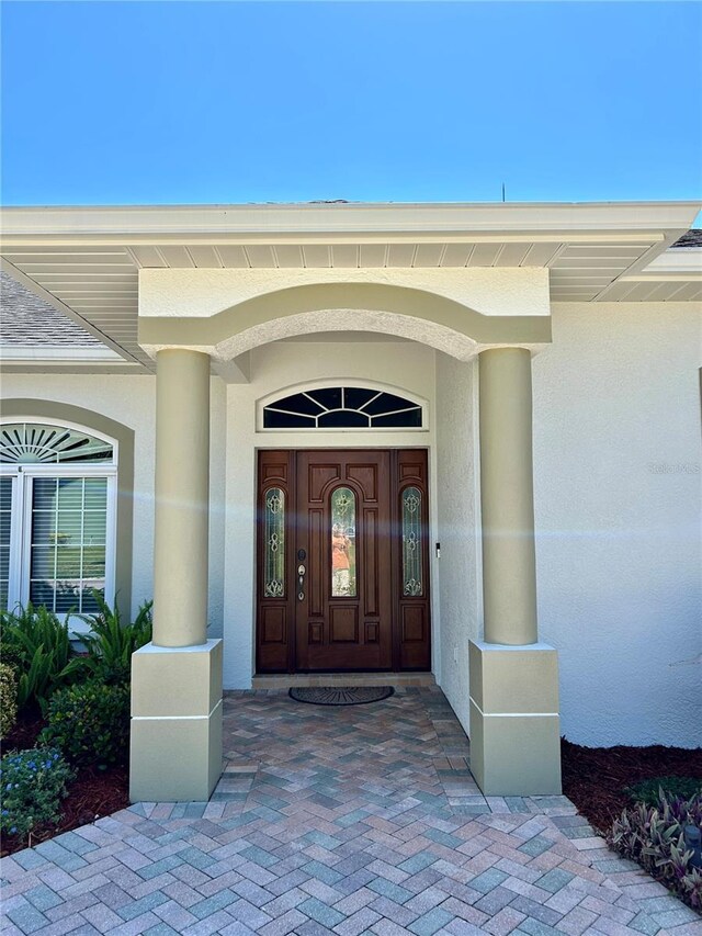 1201 Ventana Dr, Sun City Center, FL 33573 - view of exterior entry featuring stucco siding