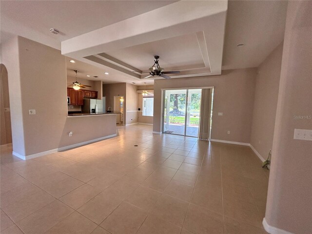 1201 Ventana Dr, Sun City Center, FL 33573 - unfurnished living room featuring light tile patterned floors, ceiling fan, a raised ceiling, and baseboards
