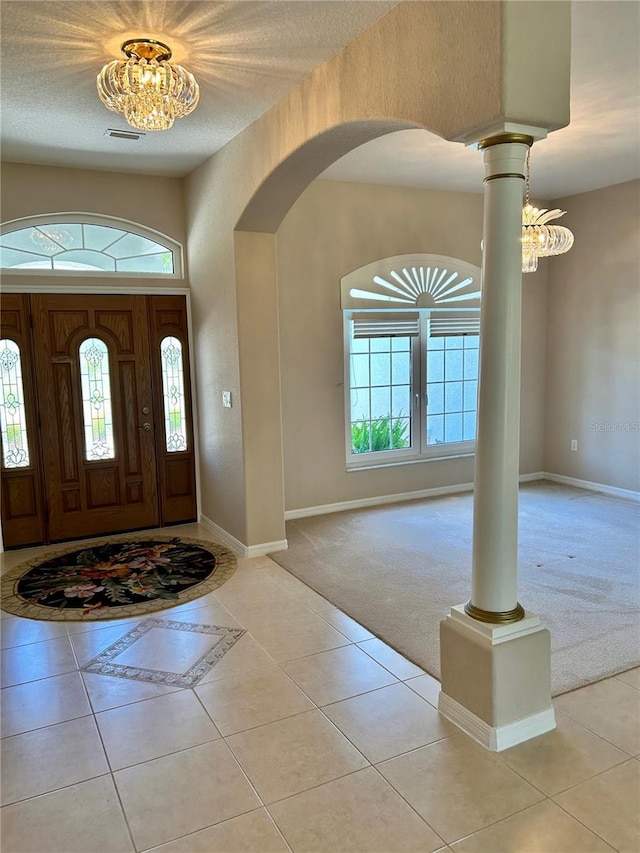 1201 Ventana Dr, Sun City Center, FL 33573 - carpeted entryway featuring arched walkways, a healthy amount of sunlight, an inviting chandelier, and tile patterned flooring