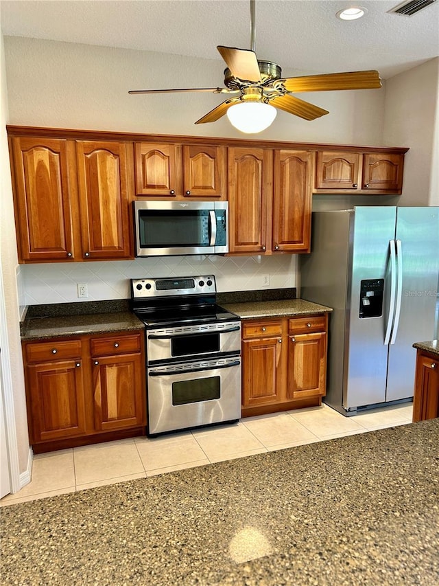 1201 Ventana Dr, Sun City Center, FL 33573 - kitchen featuring brown cabinetry, decorative backsplash, ceiling fan, and stainless steel appliances