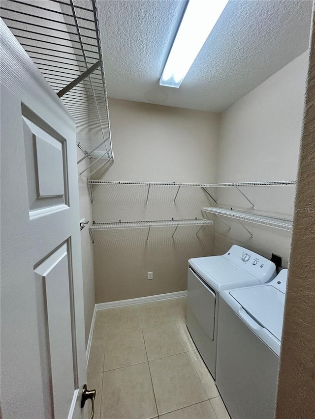 1201 Ventana Dr, Sun City Center, FL 33573 - laundry area featuring laundry area, a textured ceiling, light tile patterned flooring, baseboards, and washer and clothes dryer