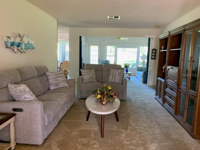 776 Lakewood Dr, Palm Harbor, FL 34684 - living area featuring visible vents, a ceiling fan, carpet, and a healthy amount of sunlight
