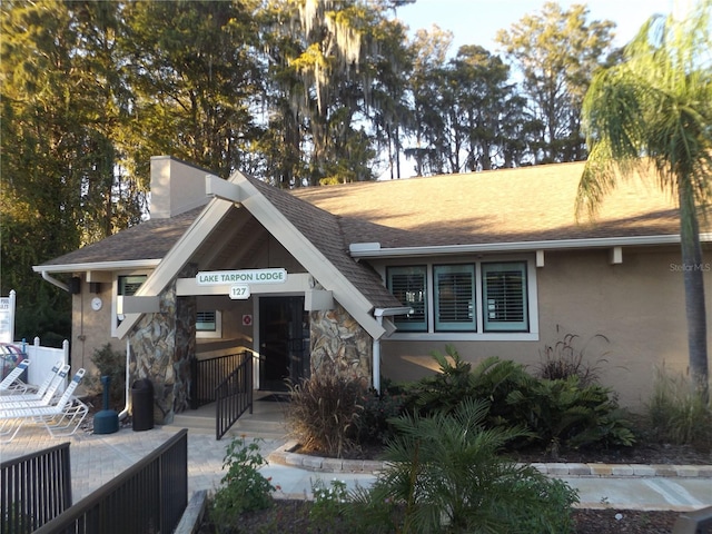 776 Lakewood Dr, Palm Harbor, FL 34684 - view of front facade with stone siding, covered porch, and stucco siding