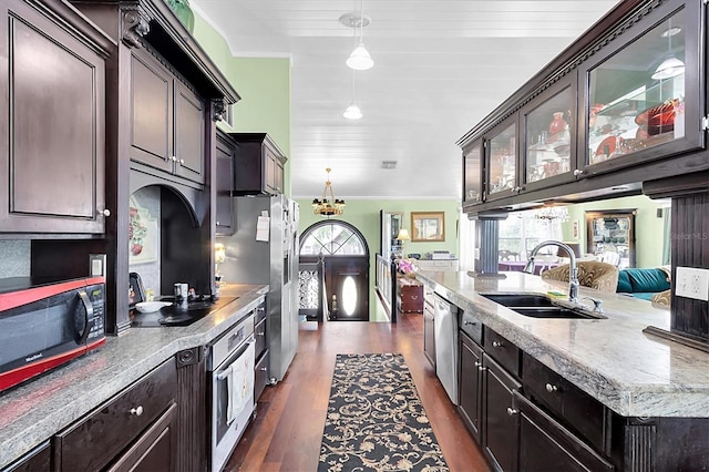 9520 Indale Dr, New Port Richey, FL 34654 - kitchen with a sink, dark wood-style flooring, glass insert cabinets, appliances with stainless steel finishes, and hanging light fixtures