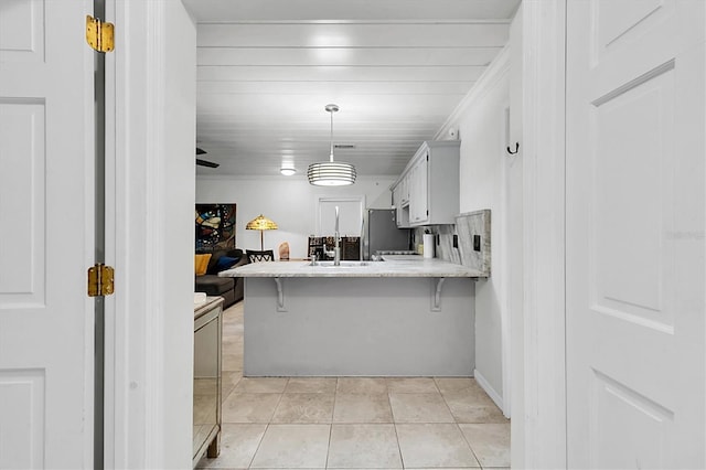 9520 Indale Dr, New Port Richey, FL 34654 - kitchen featuring a sink, light tile patterned floors, light countertops, a peninsula, and freestanding refrigerator