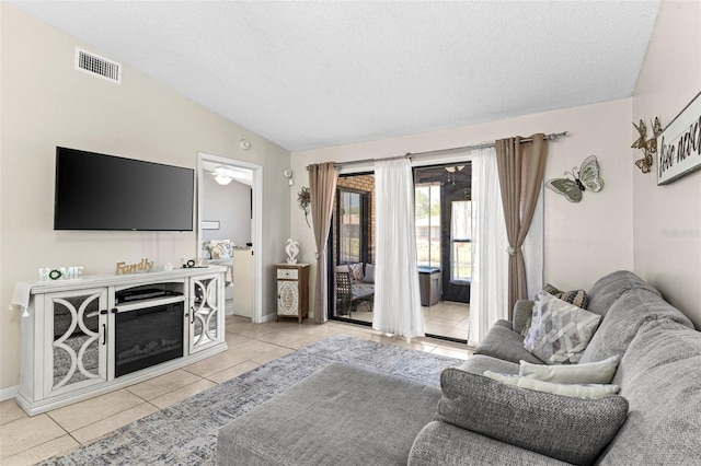 living area with tile patterned floors, visible vents, and a textured ceiling