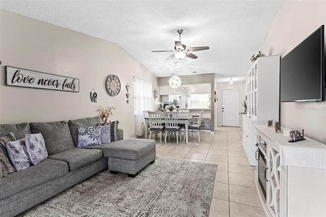 living area featuring light tile patterned floors, ceiling fan, a textured ceiling, and lofted ceiling