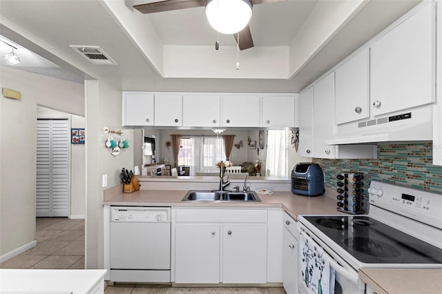 kitchen with under cabinet range hood, white appliances, light countertops, and a sink