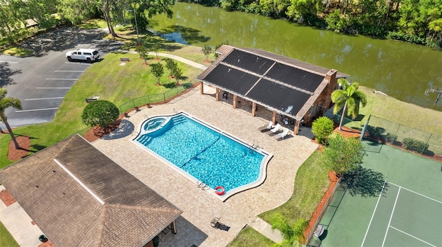 pool featuring a water view, a patio, and fence