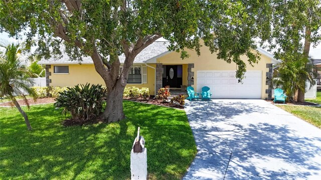 907 Golf Island Dr, Apollo Beach, FL 33572 - view of front facade featuring driveway, stucco siding, an attached garage, and a front yard