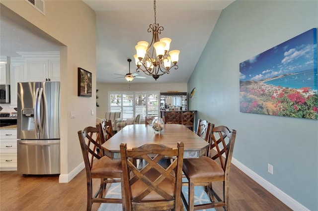 907 Golf Island Dr, Apollo Beach, FL 33572 - dining room featuring wood finished floors, ceiling fan, a chandelier, baseboards, and lofted ceiling
