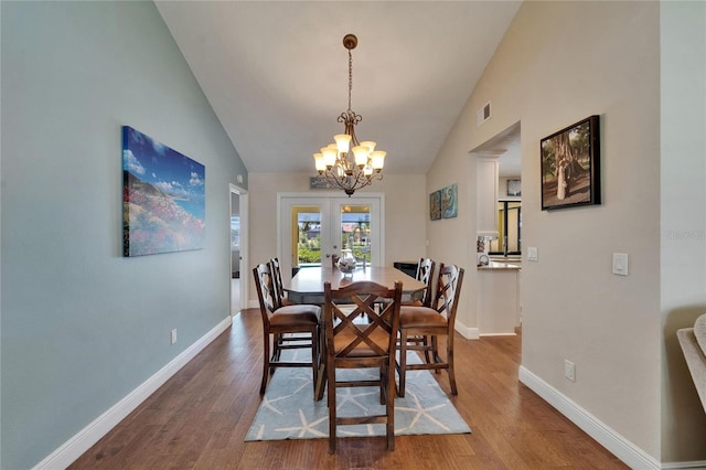 907 Golf Island Dr, Apollo Beach, FL 33572 - dining room featuring a chandelier, wood finished floors, baseboards, high vaulted ceiling, and french doors