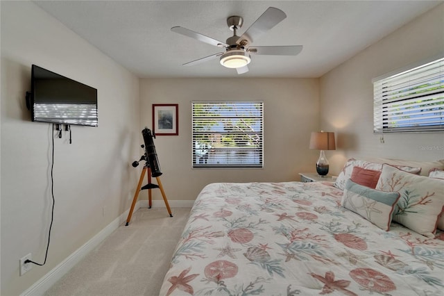 907 Golf Island Dr, Apollo Beach, FL 33572 - bedroom with light carpet, multiple windows, baseboards, and ceiling fan