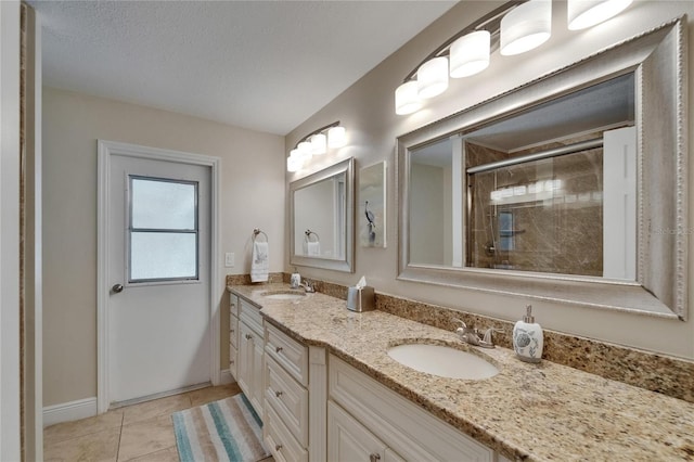 907 Golf Island Dr, Apollo Beach, FL 33572 - full bath with double vanity, tiled shower, baseboards, tile patterned flooring, and a textured ceiling