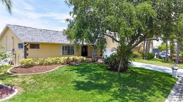 907 Golf Island Dr, Apollo Beach, FL 33572 - view of front of home featuring stucco siding, a front lawn, and roof with shingles