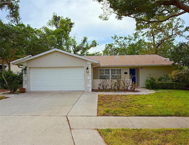 ranch-style house with stucco siding, an attached garage, driveway, and a front yard