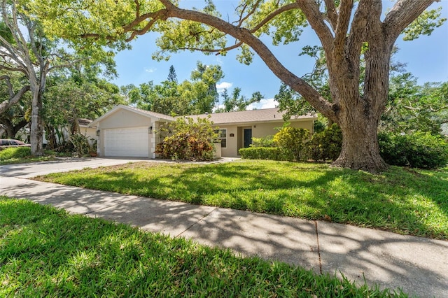 single story home featuring stucco siding, driveway, an attached garage, and a front yard
