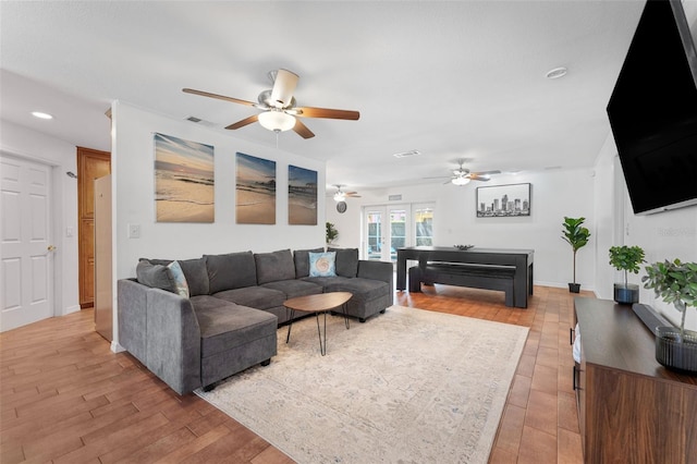 living room featuring ceiling fan, light wood finished floors, recessed lighting, and baseboards