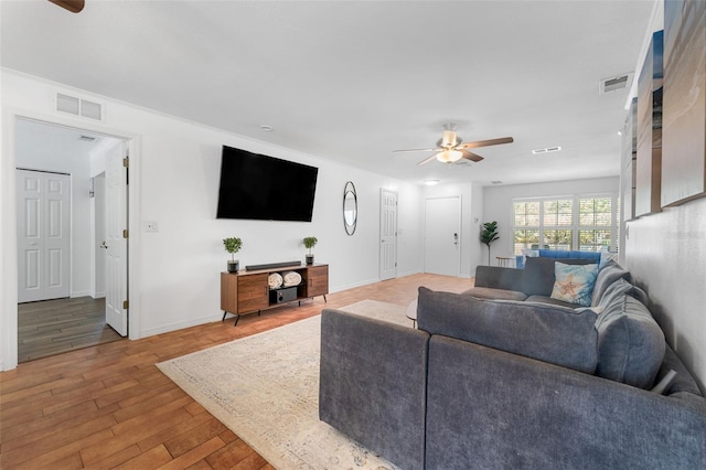 living area featuring a ceiling fan, wood finished floors, and baseboards