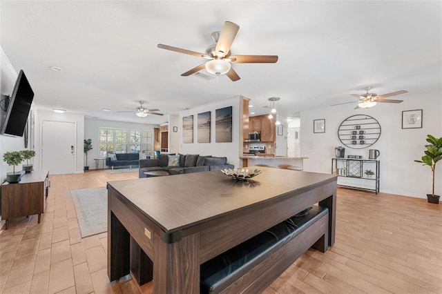 dining area featuring a ceiling fan, light wood-style flooring, and baseboards