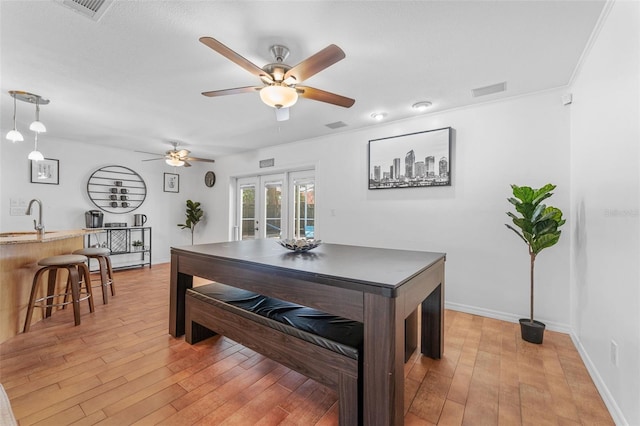dining space with french doors, ceiling fan, light wood-type flooring, and baseboards