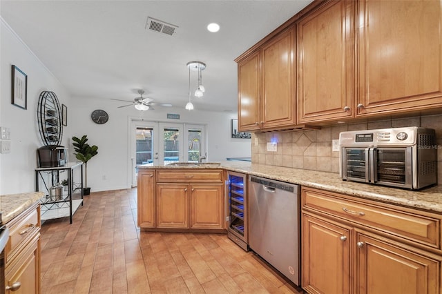 kitchen featuring dishwasher, a sink, ceiling fan, a peninsula, and backsplash