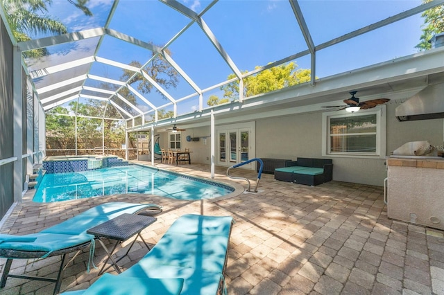 view of pool with french doors, ceiling fan, a patio area, a lanai, and a pool with connected hot tub