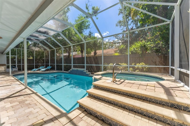 view of pool featuring an in-ground hot tub, a fenced backyard, a patio area, and glass enclosure