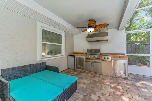 view of patio / terrace with an outdoor kitchen, ceiling fan, grilling area, a sink, and fence