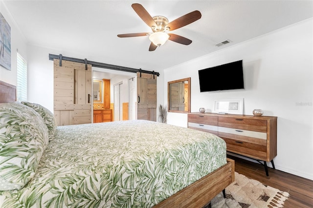 bedroom featuring a barn door, wood finished floors, ornamental molding, ceiling fan, and baseboards