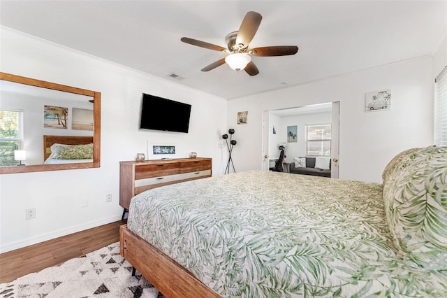 bedroom with wood finished floors, baseboards, and a ceiling fan