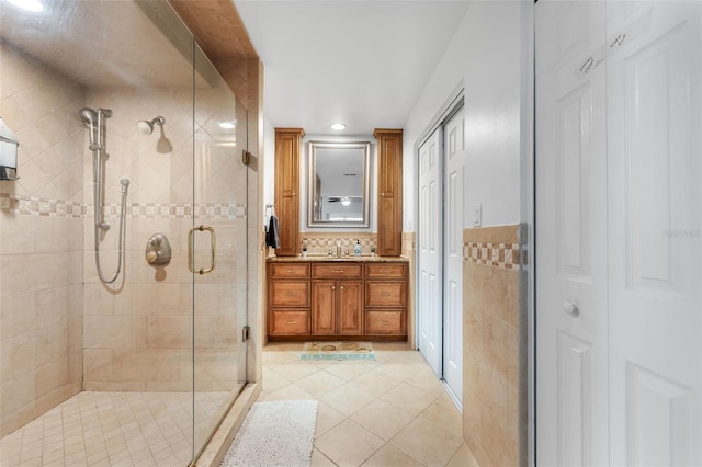 bathroom with a stall shower, tile patterned flooring, vanity, recessed lighting, and tile walls
