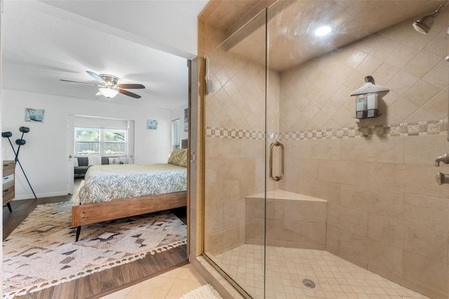 full bath with connected bathroom, a shower stall, ceiling fan, wood finished floors, and baseboards