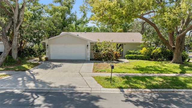 view of front of home featuring an attached garage, concrete driveway, a front yard, and stucco siding