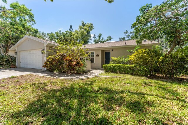 ranch-style home featuring stucco siding, a front yard, concrete driveway, and an attached garage