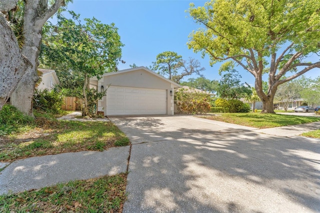 view of front facade featuring concrete driveway, an attached garage, and stucco siding