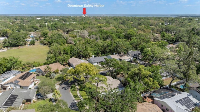 view of property location featuring nearby suburban area and a forest