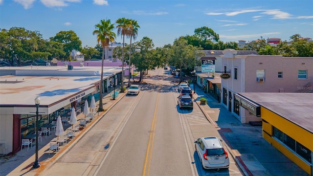 view of asphalt street with sidewalks and curbs