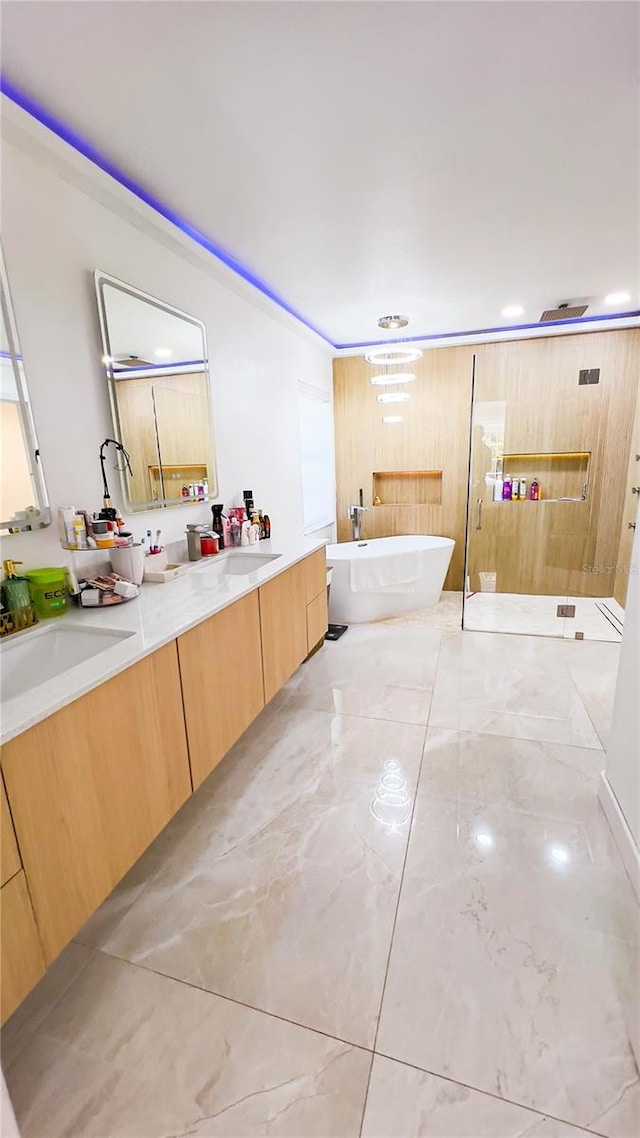 full bath with a freestanding bath, a sink, double vanity, a walk in shower, and marble finish floor
