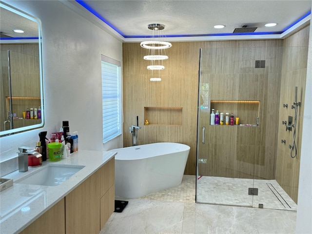bathroom with a shower stall, a freestanding bath, vanity, and recessed lighting