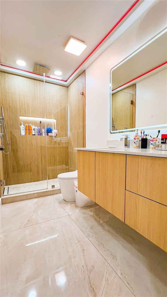 full bath featuring toilet, vanity, marble finish floor, and a stall shower