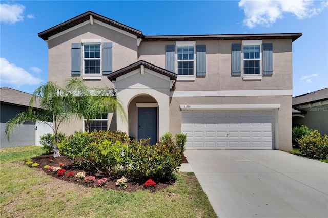 traditional home featuring a garage, stucco siding, and driveway