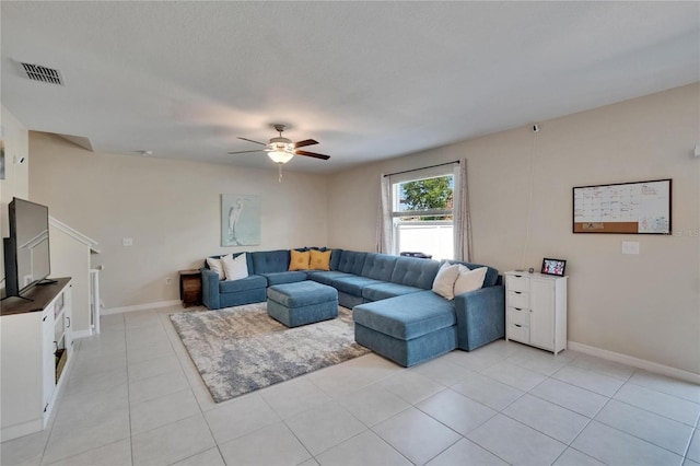living room with visible vents, ceiling fan, light tile patterned floors, and baseboards