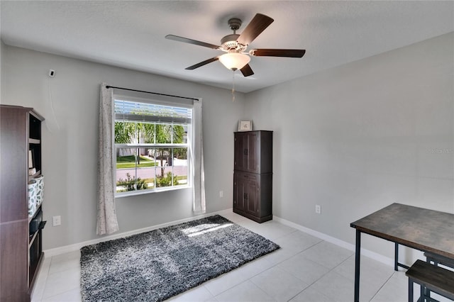 entryway with ceiling fan, baseboards, and light tile patterned floors