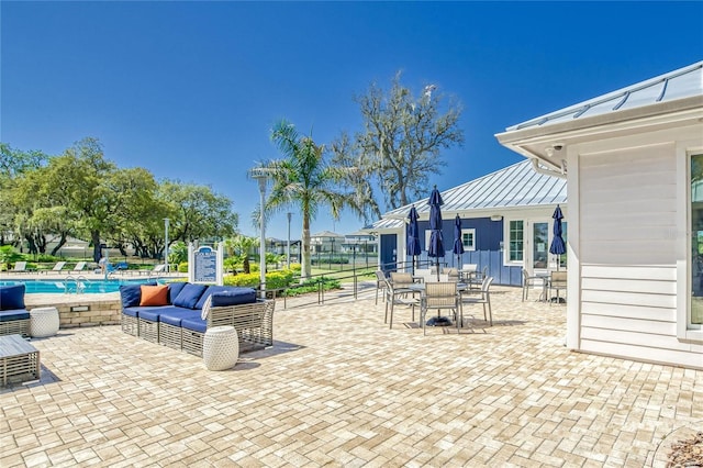 view of patio with outdoor lounge area, a community pool, and outdoor dining area