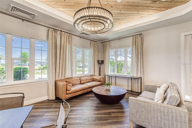 living area with visible vents, baseboards, wooden ceiling, a notable chandelier, and a tray ceiling