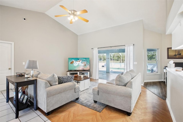 living room featuring baseboards, high vaulted ceiling, and ceiling fan