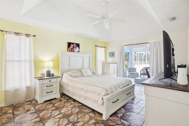 bedroom featuring vaulted ceiling, visible vents, access to exterior, stone finish flooring, and ceiling fan
