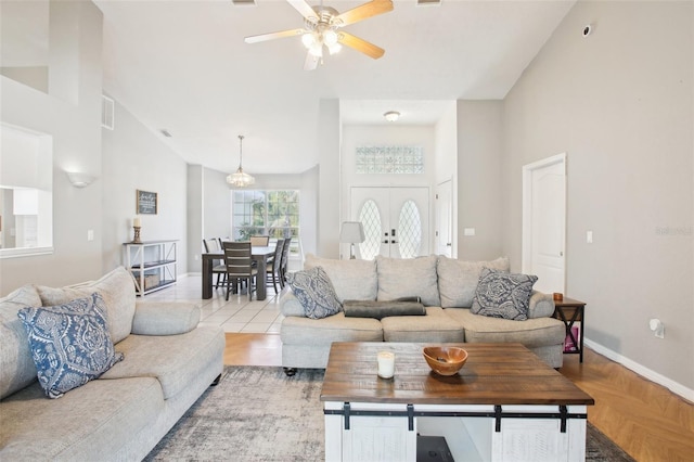 living area featuring visible vents, french doors, baseboards, high vaulted ceiling, and ceiling fan